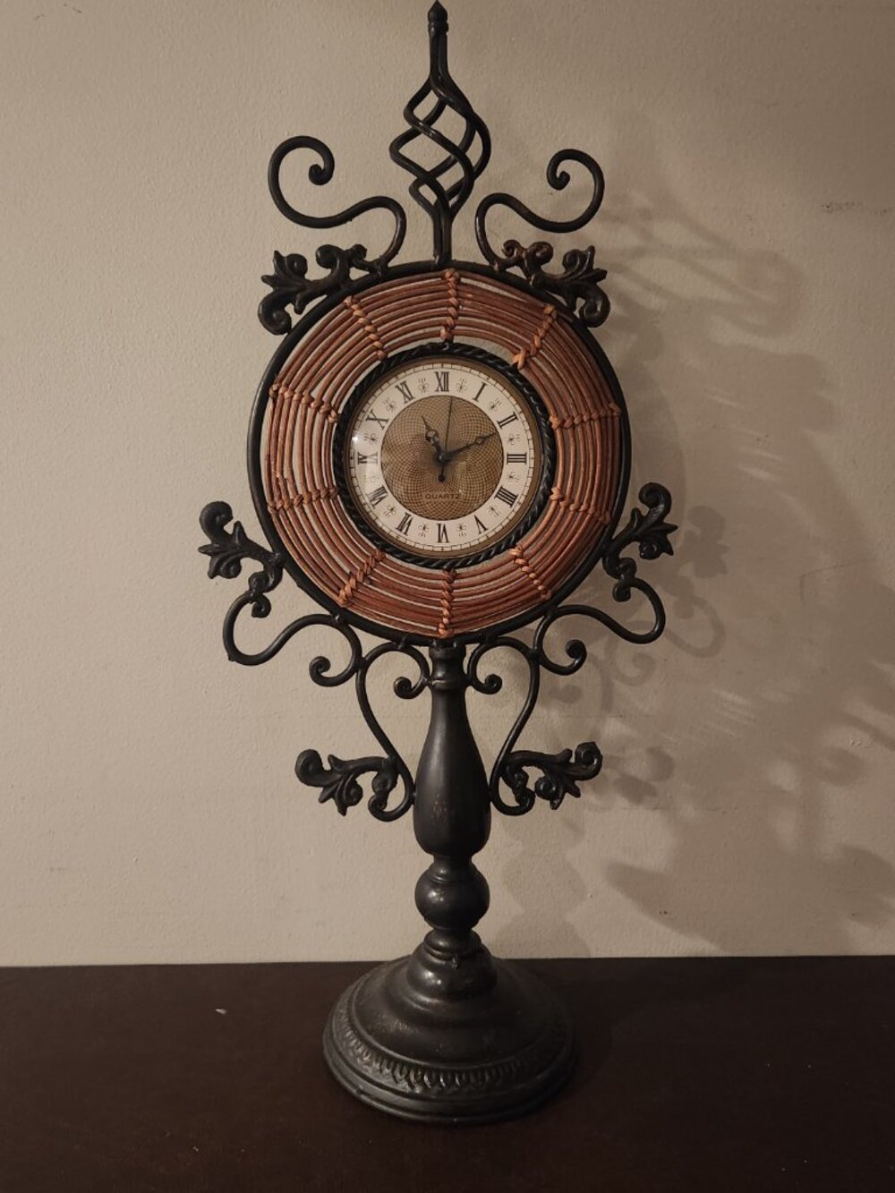 Decorative Iron Mantel Clock features a woven rattan frame Roman numeral dial